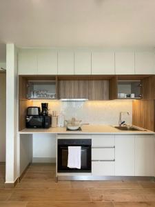 a kitchen with white cabinets and a sink at Nyali Evoque - BriSta Stays in Mombasa