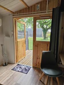 an open door of a tiny house with a chair at Chalet La Savane in Le Gond