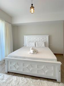 a white bed in a bedroom with a white bed frame at Nyali Evoque - BriSta Stays in Mombasa