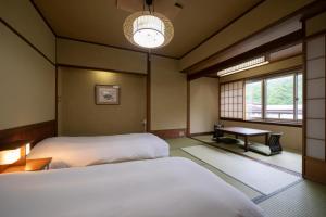 a room with two beds and a window at Hirayukan in Takayama