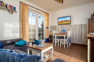 a living room with a couch and a table at Strandhaus zum Lotsenturm in Thiessow