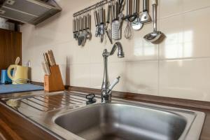 a kitchen with a stainless steel sink and utensils at Strandhaus zum Lotsenturm in Thiessow +33 photos