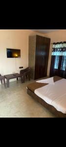 a bedroom with a large bed and a table at The Mount lakes in Bhīm Tāl +3 photos
