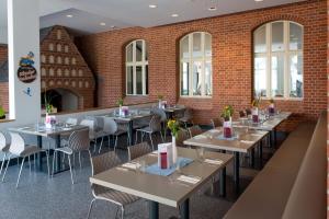 een restaurant met tafels en stoelen en een bakstenen muur bij Jugendherberge Berlin Ostkreuz in Berlijn