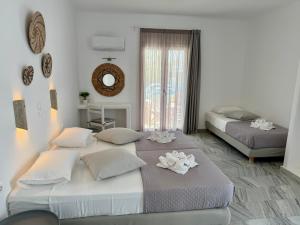 a bedroom with two beds and a mirror at Magginas Studios in Parikia