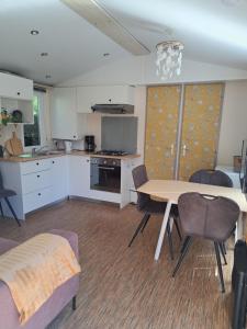 a kitchen and dining room with a table and chairs at De Huisbij in Oude Willem