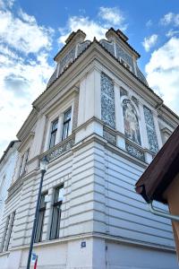 a tall white building with a clock tower at Elbe Stay Roudnice in Roudnice nad Labem