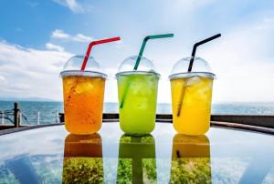 three drinks on a table with the ocean in the background at HOTEL OK GREEN TEA -Condo with ocean view- in Sonogi