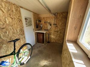 a bike parked in a room with a stone wall at Le printemps, gîte nature in Bruyères