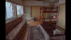 a living room with a couch and a book shelf at HOTEL OK GREEN TEA -Condo with ocean view- in Sonogi