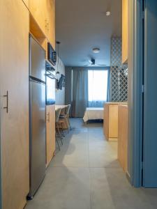 a room with a refrigerator and a kitchen with a bed at Downtown photographer's studio 2 in Korinthos