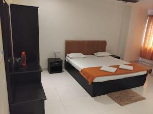 a bedroom with a bed and a black dresser and a bed sidx sidx sidx at Pibo Homestay in Port Blair