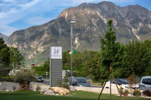 a sign in a parking lot with a mountain in the background at Park Hotel Gemona in Gemona del Friuli