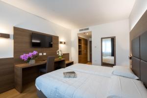 a bedroom with a bed and a desk and a television at Park Hotel Gemona in Gemona del Friuli