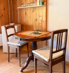 a wooden table with two chairs and a table with at Blüemlisalp-Huus im Kiental in Kiental +10 photos