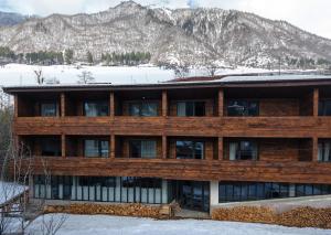 a house in the snow with mountains in the background at Lasiim in Mestia
