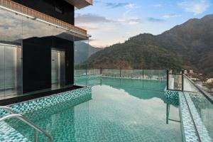 a swimming pool with a view of a mountain at ZANA by the Ganges, Tapovan, Rishikesh in Rishīkesh