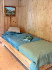 a bed in a wooden room with a wooden wall at Blüemlisalp-Huus im Kiental in Kiental