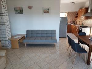 a living room with a couch and a table and a kitchen at Szikszai Apartman in Balatonfůzfő