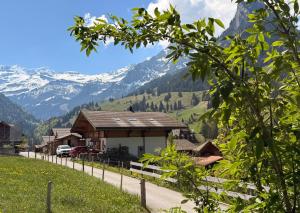 a house on a hill with mountains in the background at Blüemlisalp-Huus im Kiental in Kiental