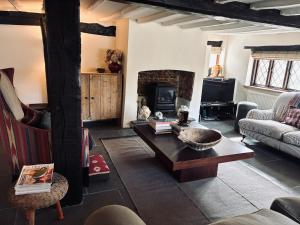 a living room with a coffee table and a fireplace at Cottage in the Hambleden Valley in Henley on Thames