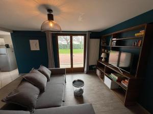 a living room with a couch and a large window at Logement indépendant avec jardin in Beaune