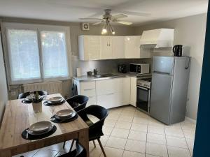 a kitchen with a table and a refrigerator at Logement indépendant avec jardin in Beaune