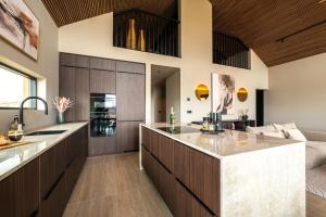 an open kitchen with wooden cabinets and a large island at Modern Aurora Retreat in Selfoss