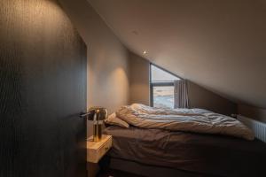a bed in a room with a window at Modern Aurora Retreat in Selfoss