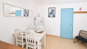 a kitchen with a table and chairs and a refrigerator at MES VACANCES A LA MER studio 4 pers, parking privé, wifi, linges fournis, climatisation in La Grande Motte