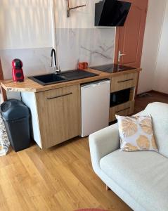 a kitchen with a sink and a couch in a room at Blez kò in Vaucouleurs