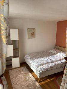 a small bedroom with a bed and a shelf at Blez kò in Vaucouleurs