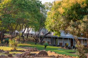 a white house with trees in front of it at Kambiri Beach by Serendib in Senga