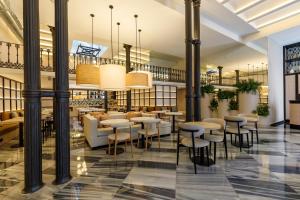 a restaurant with tables and stools in a lobby at Petit Palace Plaza de la Reina in Valencia