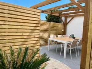 a wooden fence with a table and chairs at Les Cabines de la Vie in Saint-Gilles-Croix-de-Vie
