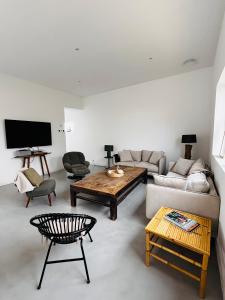 a living room with a couch and a table at Villa Wax - Piscine et plage in Santec