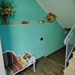 a staircase with blue walls and a chair with flowers at B&B Luxury Suite Le Gladiaroom in Santa Maria Capua Vetere