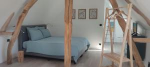a bedroom with a blue bed and a ladder at La Dépendance d'En Face in Huppy