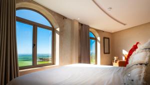 a bedroom with a large bed and large windows at Bhalil Farm House in Sefrou +72 photos