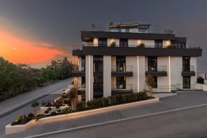 a building with a sunset in the background at Boutique Hill Hotel in Požarevac