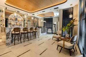 a lobby with a bar with stools and tables at Boutique Hill Hotel in Požarevac