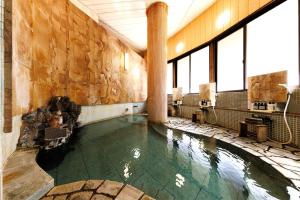 a pool in the middle of a building with water in it at Yamayuri no Yado in Hanamaki