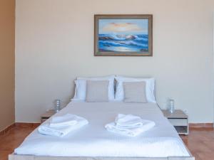 a white bed with two white towels on it at Sunset apartment by the sea in Palaiochórion +31 photos