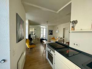 a kitchen with a counter top and a living room at appartement centre ville in Souillac