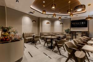 a dining room with tables and chairs and a chalkboard at Boutique Hill Hotel in Požarevac