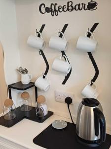 a kitchen counter with a coffee bar sign on the wall at An Mor Haven in Coverack +21 photos