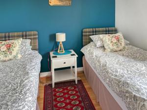 two beds sitting next to each other in a room at Kildonan in Laide