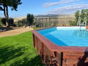 a large swimming pool in a yard with grass at La Casa del Rincón in Estación de la Hoya