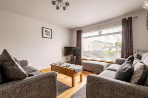 a living room with two couches and a tv at Dreelside - No 50 in Anstruther