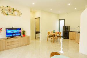 a living room with a television and a dining room at Libra House Phu Quoc in Phú Quốc